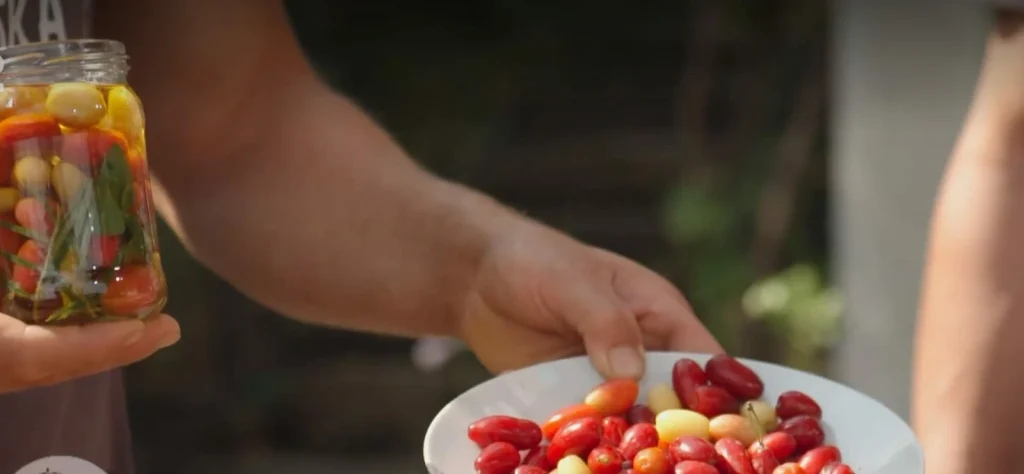 Fermentované drienky v pohári a čerstvé v tanieri.